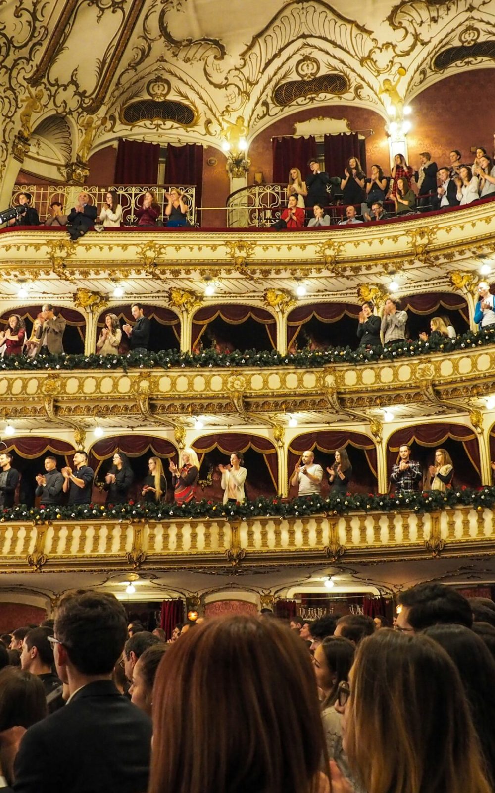 The plush red velvet clad interior of a nineteenth century style theatre auditorium